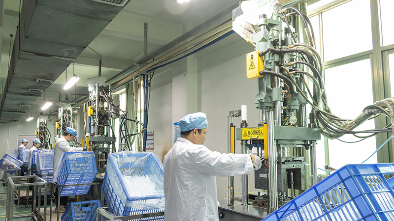 Factory workers manufacturing plastic cosmetic tubes, focusing on eco - friendly & customizable types Workers in cleanroom suits operate machines to produce plastic cosmetic tubes in factory